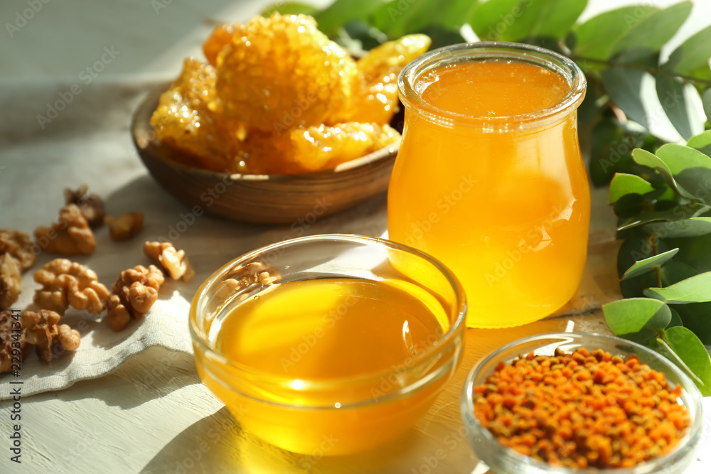 Bowl and jar with honey on table