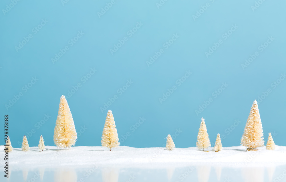 Small green and white Christmas trees in snow