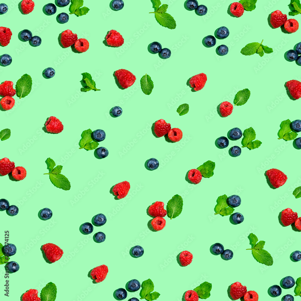 Blueberries and raspberries on a solid color background