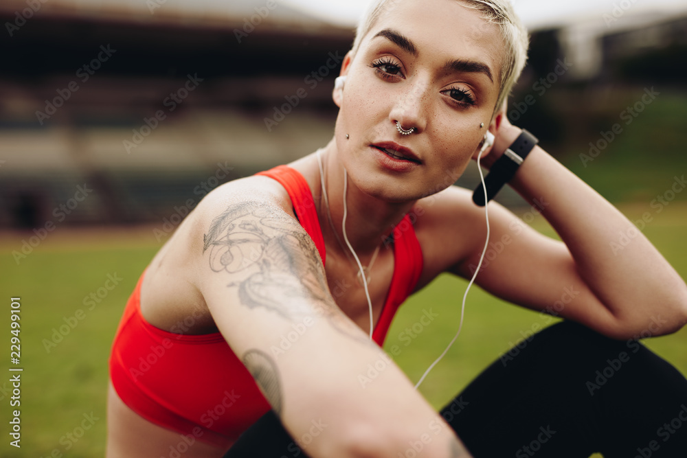 Close up of a fitness woman listening to music on earphones