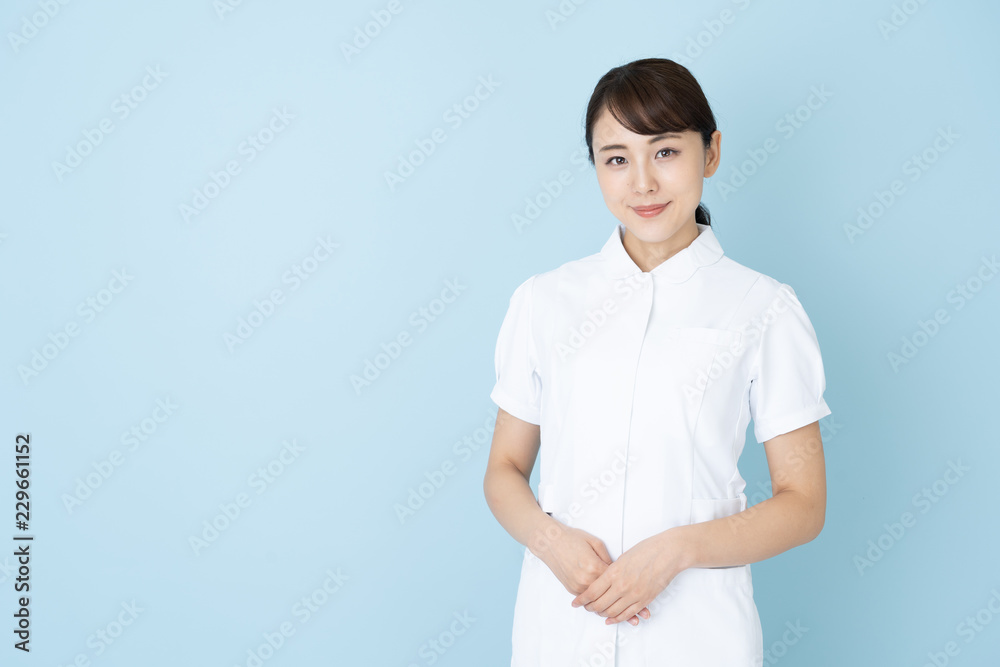 portrait of young asian nurse on blue background