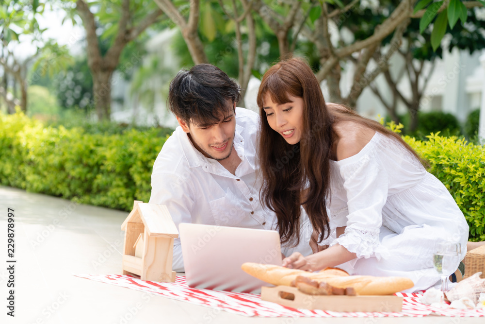 年轻夫妇夏天去公园野餐。