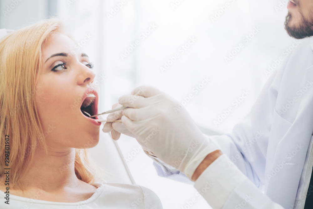 Young dentist examining patient in dental clinic.