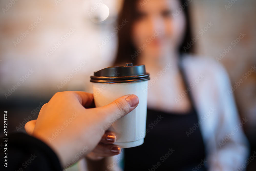 Hand of Man外卖咖啡杯女孩在现代咖啡馆提供一次性外卖热咖啡