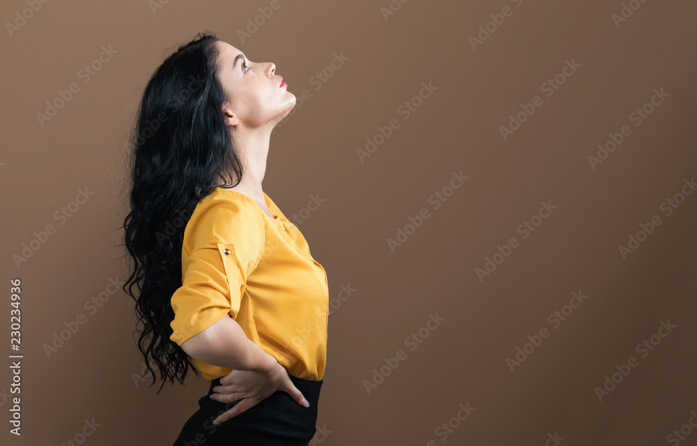 Beautiful young woman on a brown background