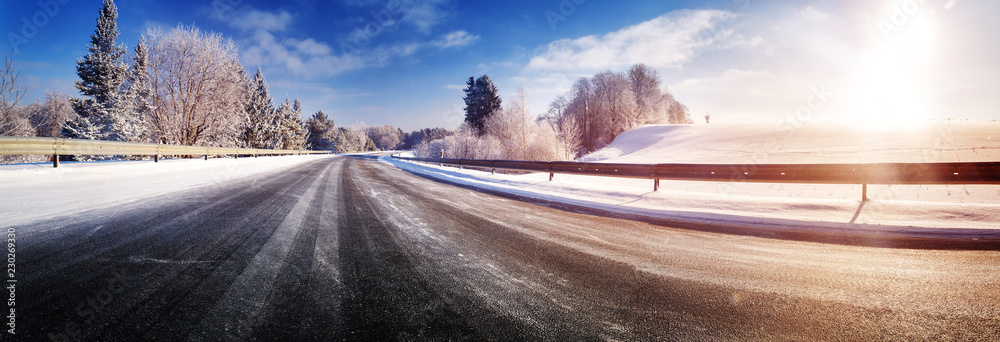 汽车在被雪覆盖的冬季道路上行驶