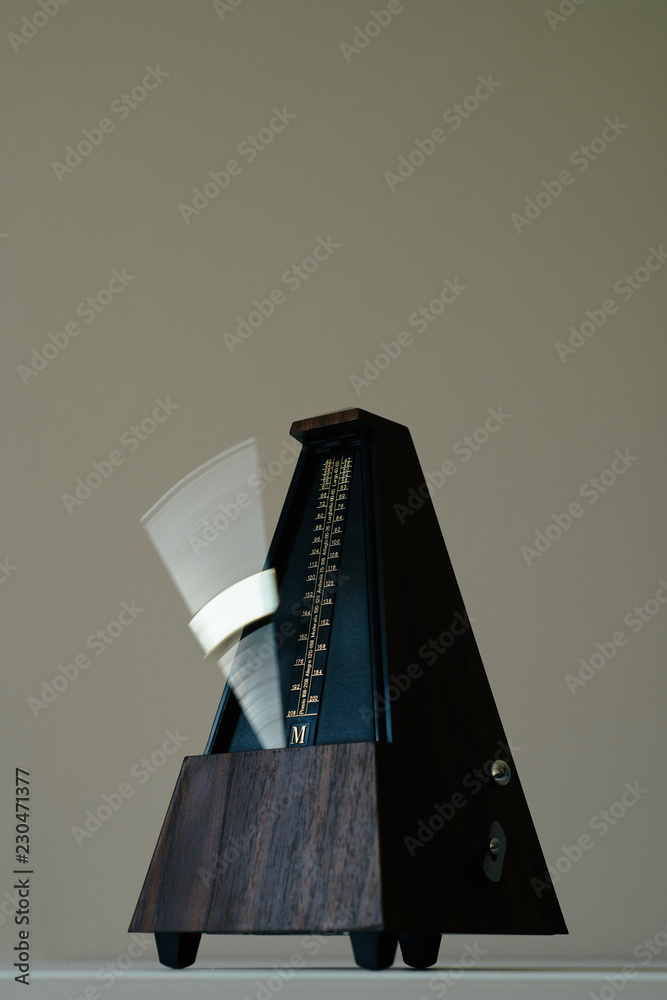 Vintage metronome, on a black background.