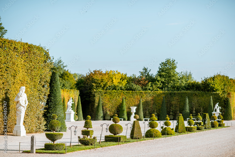 Versailles garden with beautiful sculptures, vases and trimmed bushes in Versaillle palace in France