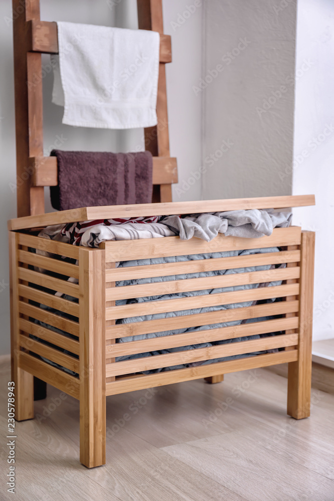 Wooden box with dirty laundry in bathroom