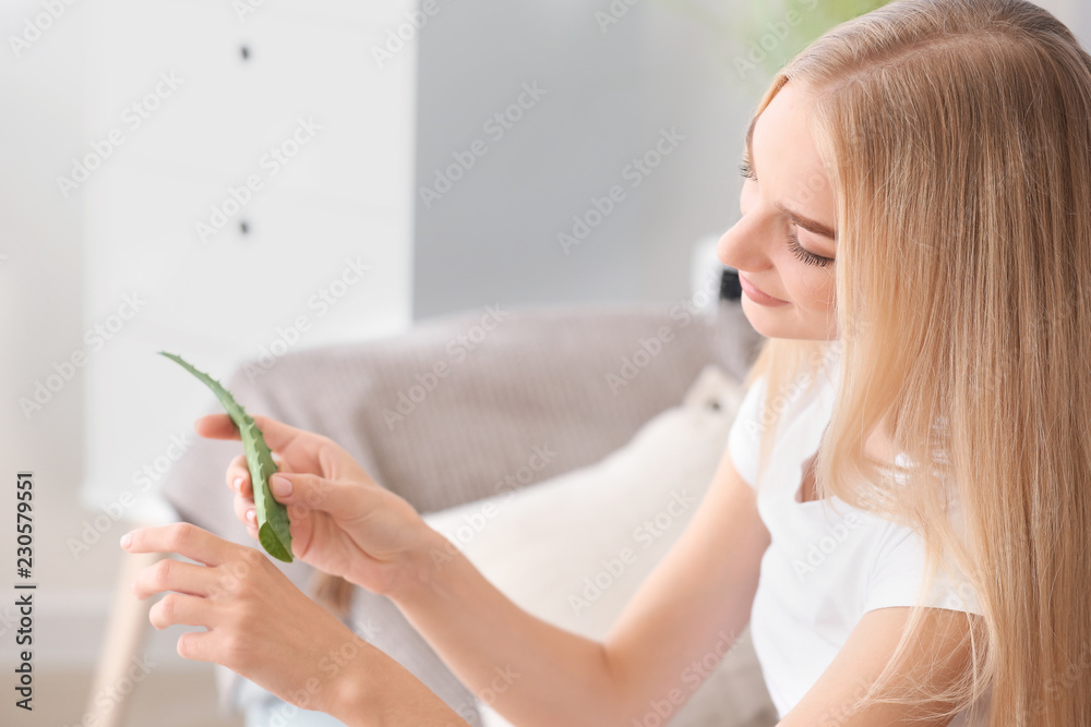 美丽的年轻女人在家里使用芦荟