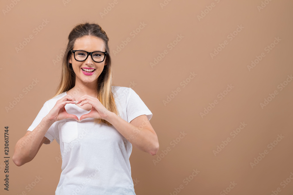 女人用手在棕色背景上做心形手势