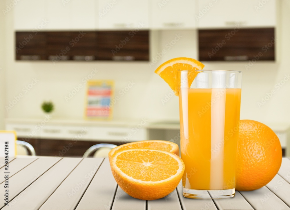 Glass of delicious orange juice on table