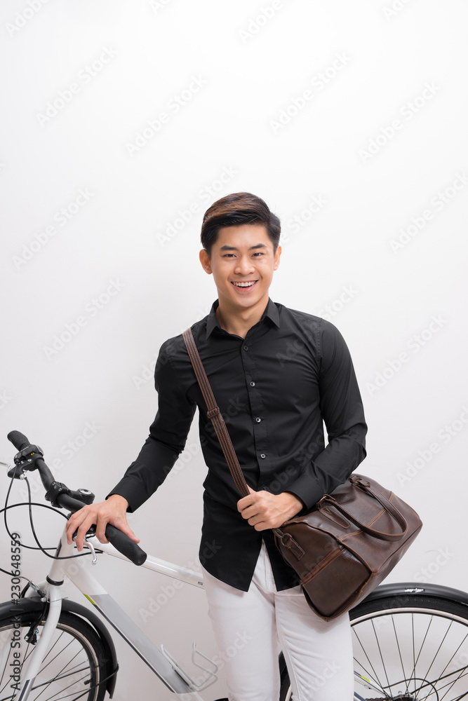 handsome young man with shoulder bag and bicycle standing isolated on white background