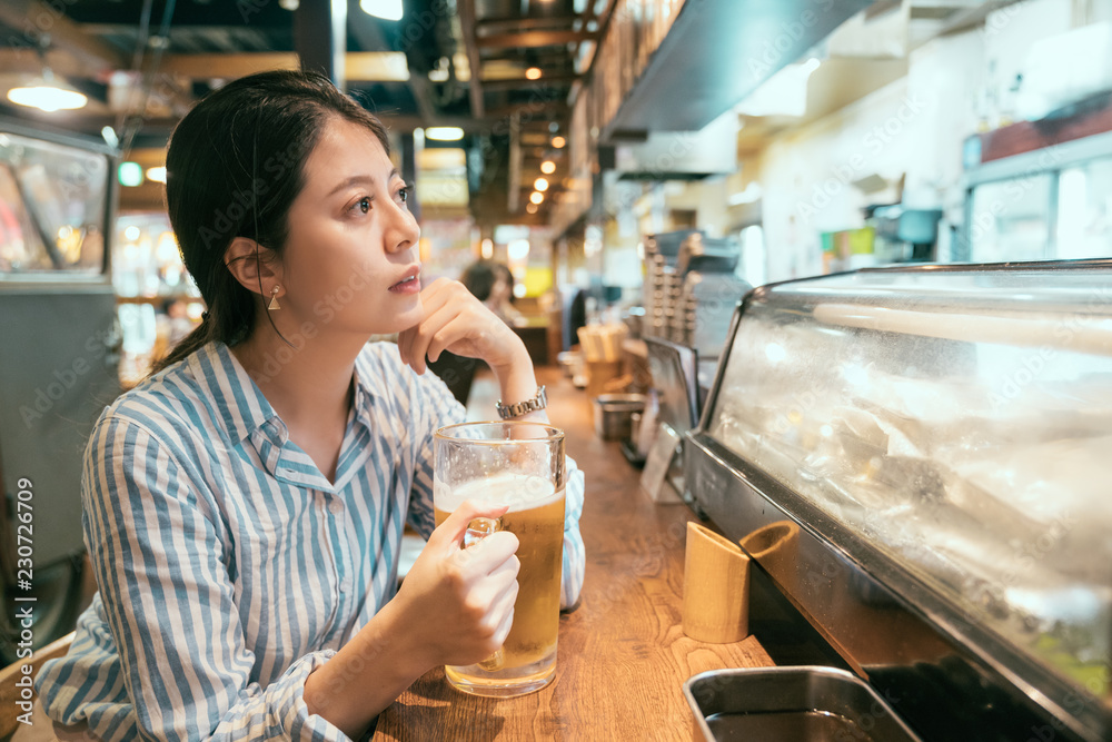 女士坐在居酒屋的柜台酒吧里