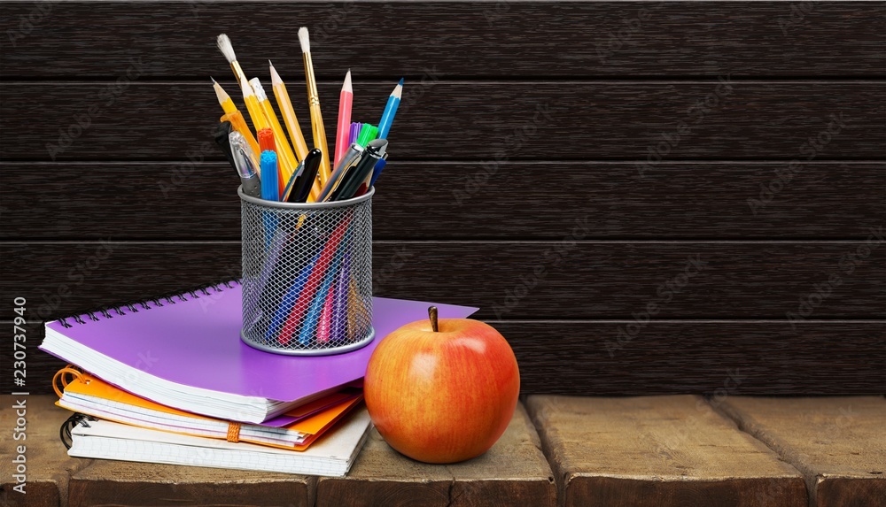 Colorful school supplies on blackboard background