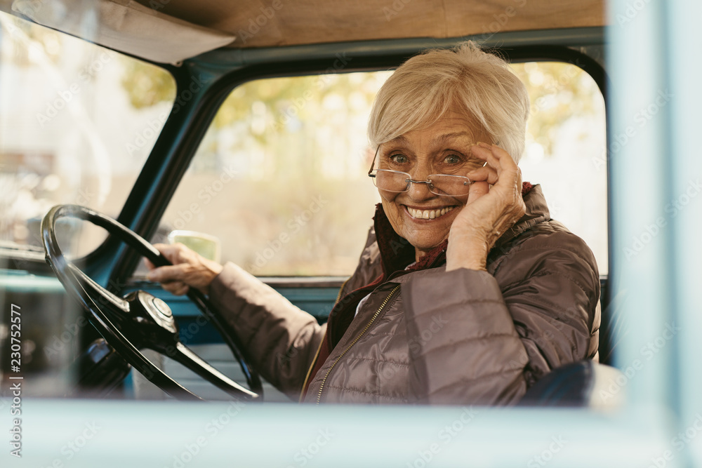 老年妇女开着一辆旧车