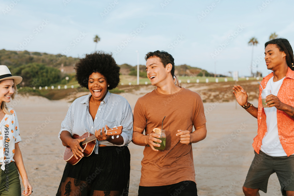 Friends singing and dancing at the beach