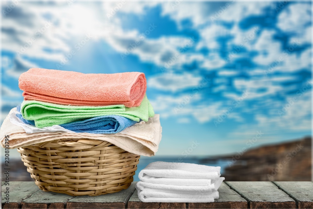 Laundry Basket with colorful towels on background