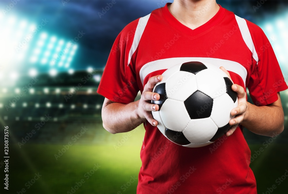 Young Male Soccer Player on blurred sport stadium background