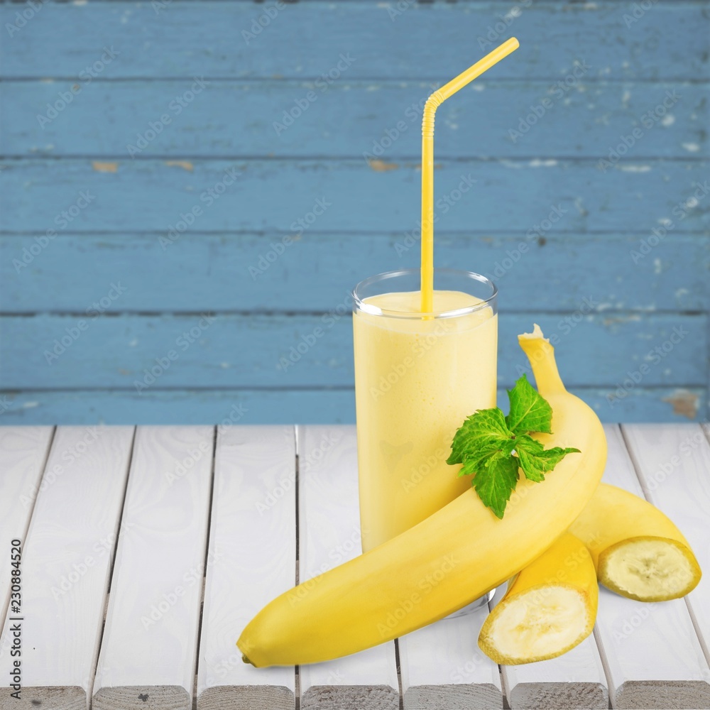 Tasty banana milkshake on wooden table