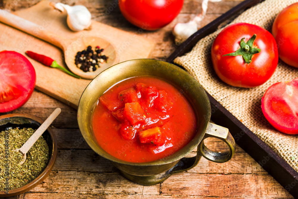 Tomatoes and tomato paste on a rustic wooden table