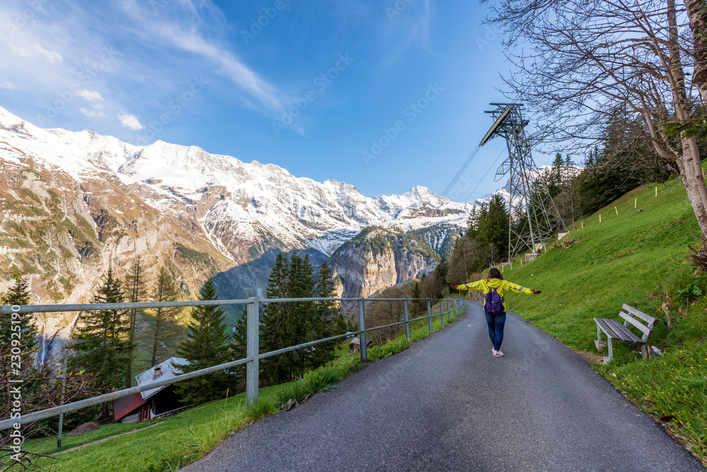 Woman traveler walking and looking to the mountains Switzerland. Beautiful landscape in Switzerland.