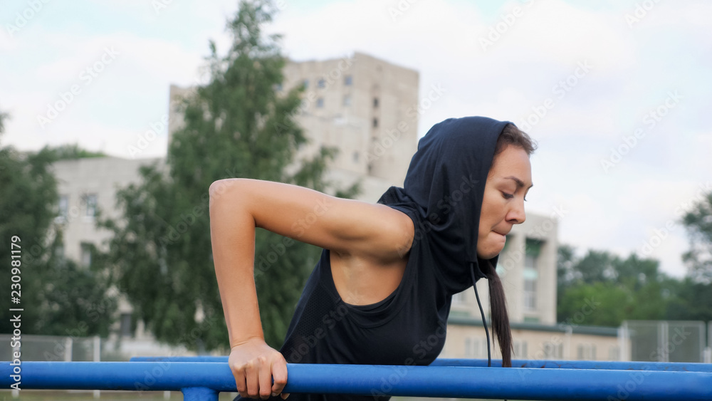 运动女孩在横梁上锻炼三头肌