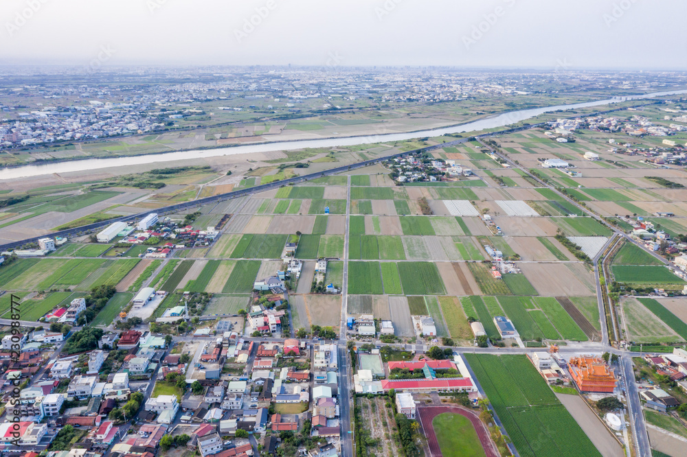 Fields with various types of agriculture and villages beside with air pollution in winter morning, T