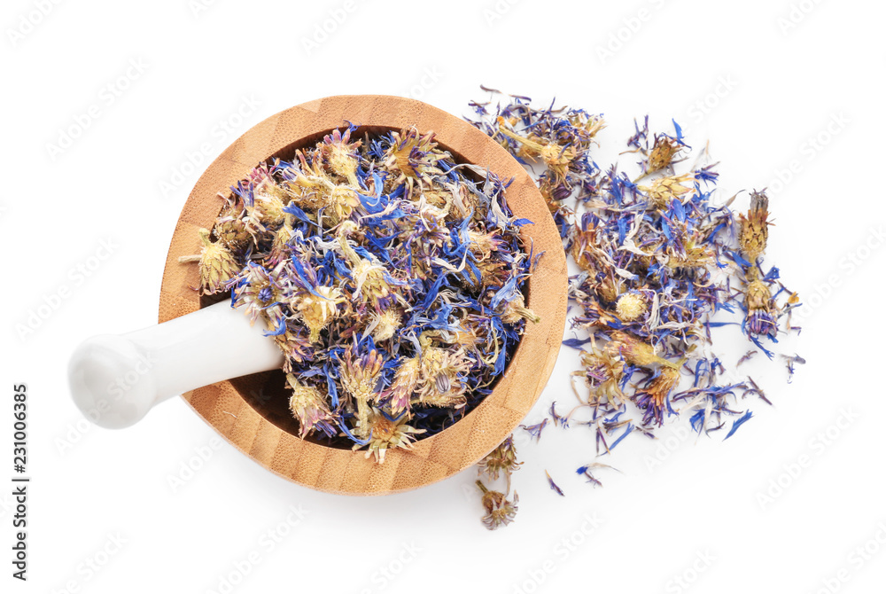 Mortar and pestle with dried flowers on white background, top view