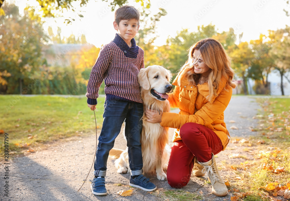 Mother with son and their dog in autumn park