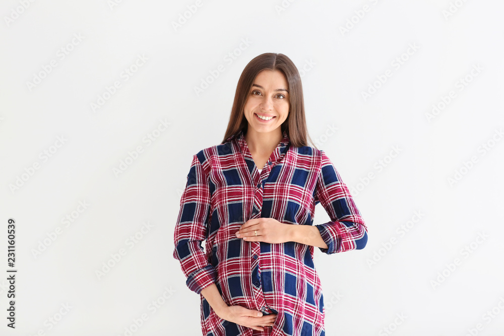 Beautiful pregnant woman on light background