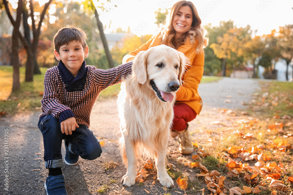 Mother with son and their dog in autumn park