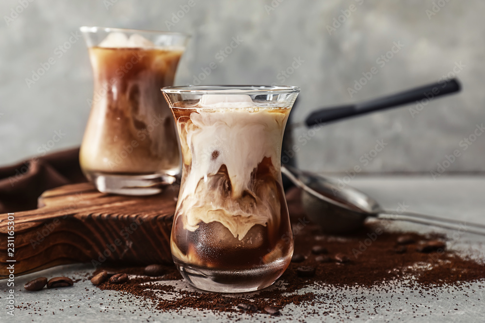 Glass with cold coffee on grey table