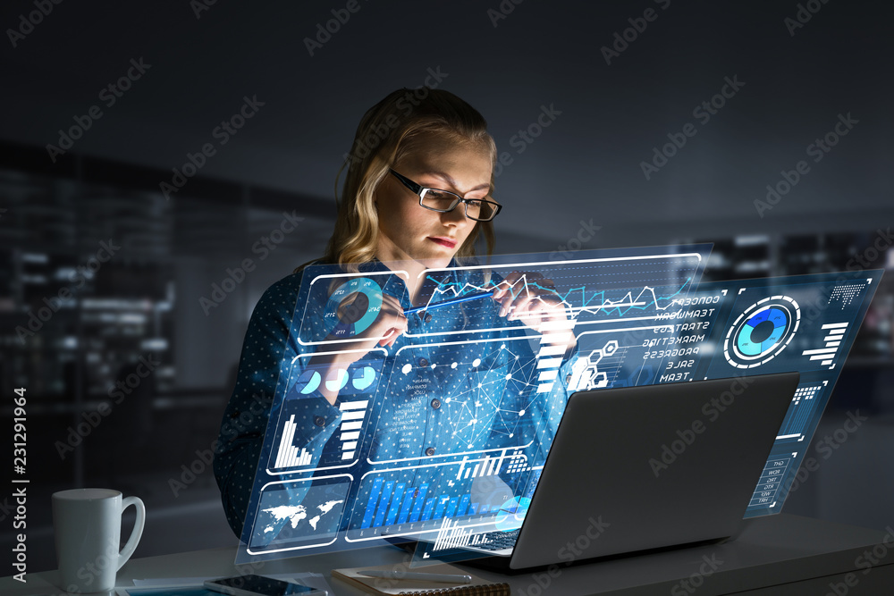 Beautiful blonde working on laptop and infographs out of screen. Mixed media