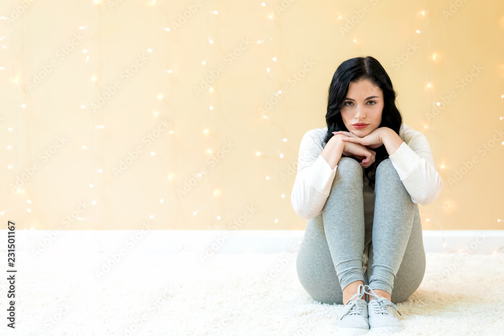 Portrait of a young woman on a shiny light background