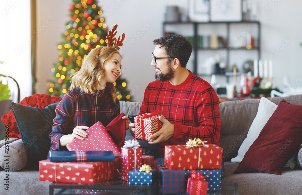 happy couple opening presents on Christmas morning