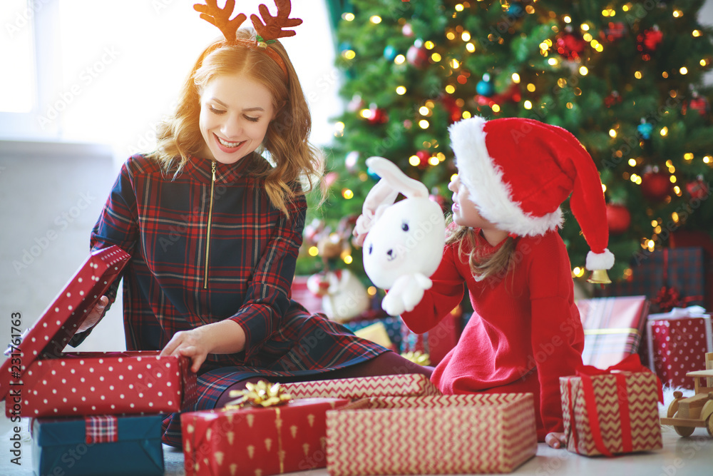 family   mother and child daughter open presents on Christmas morning