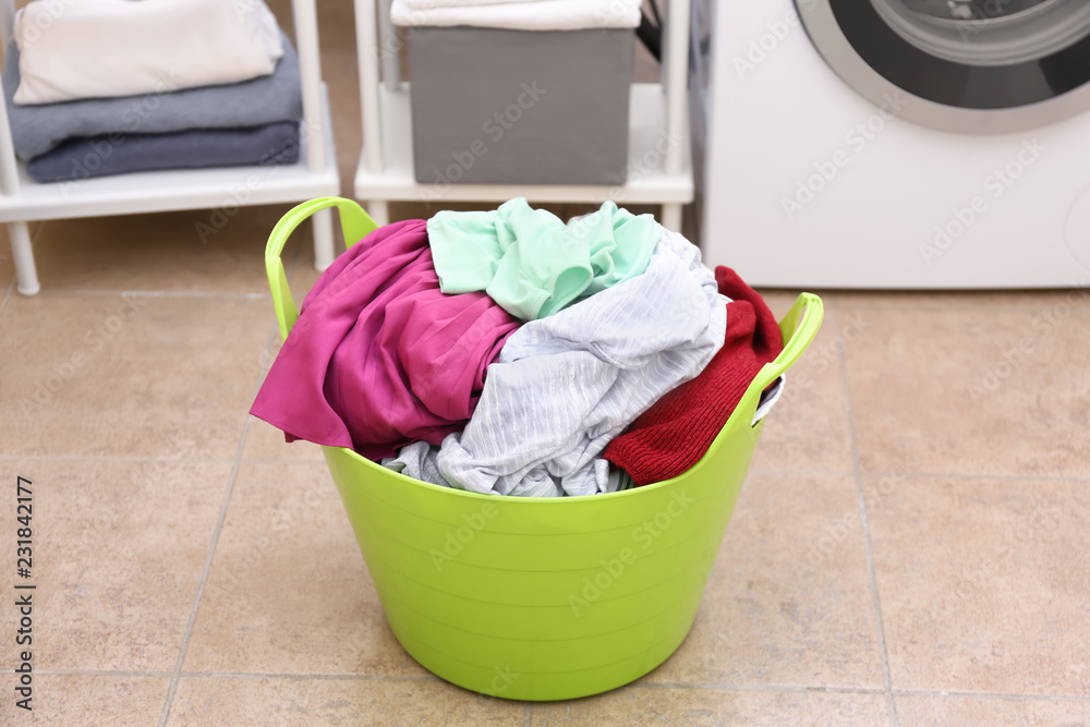 Laundry basket with dirty clothes in bathroom