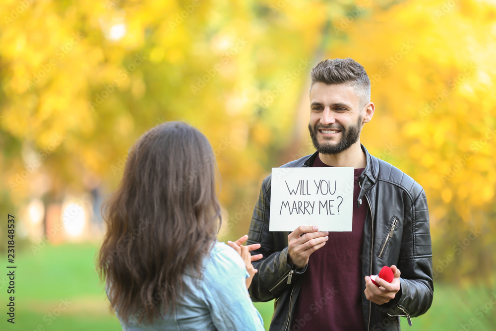 年轻人在秋季公园向心爱的人求婚