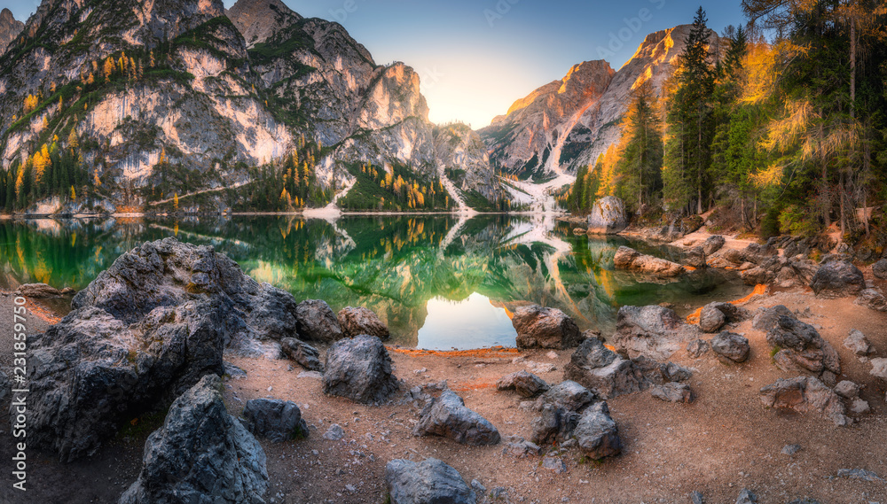 意大利多洛米蒂秋季日出时布雷斯湖畔的石头。带山的风景