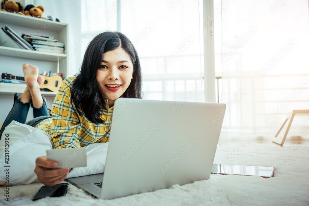 年轻的亚洲女孩是一名自由职业者，她的私人企业在家办公，用笔记本电脑和咖啡工作