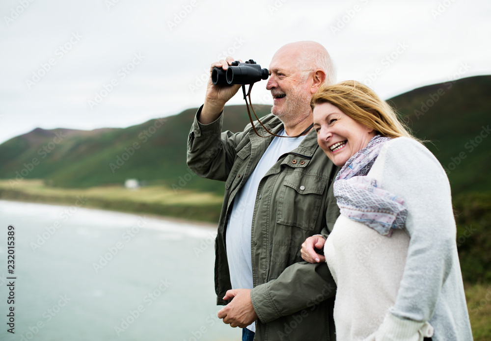 Happy senior couple enjoying with a pair of binoculars