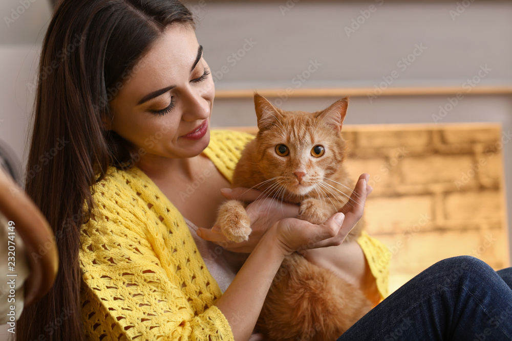 带着可爱的猫在壁炉旁休息的女人