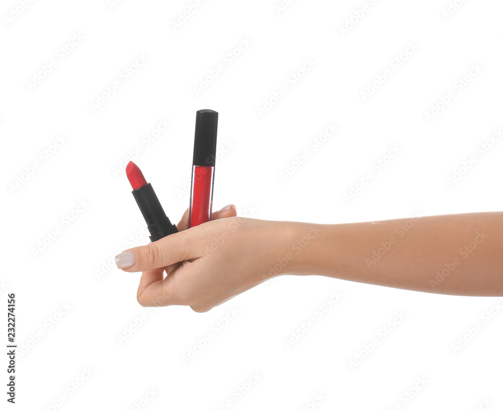 Woman holding lip gloss and lipstick on white background