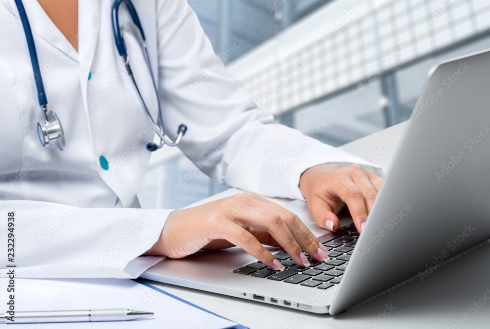 Close-up of a medical worker typing on laptop