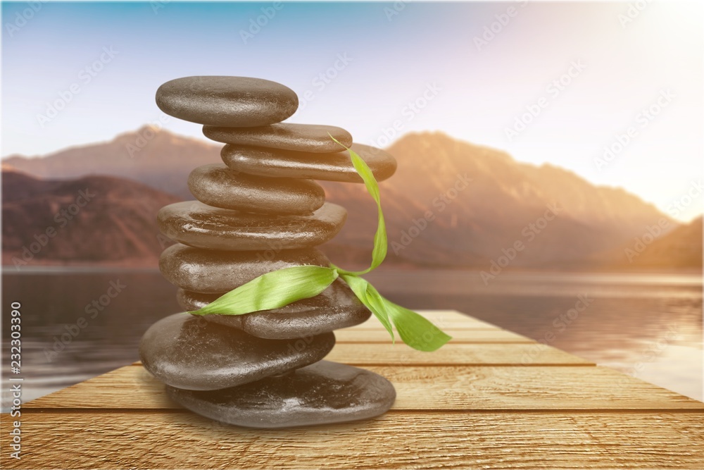 Zen basalt stones and leaves on background