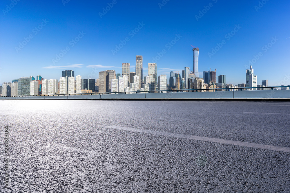 empty asphalt road with city skyline