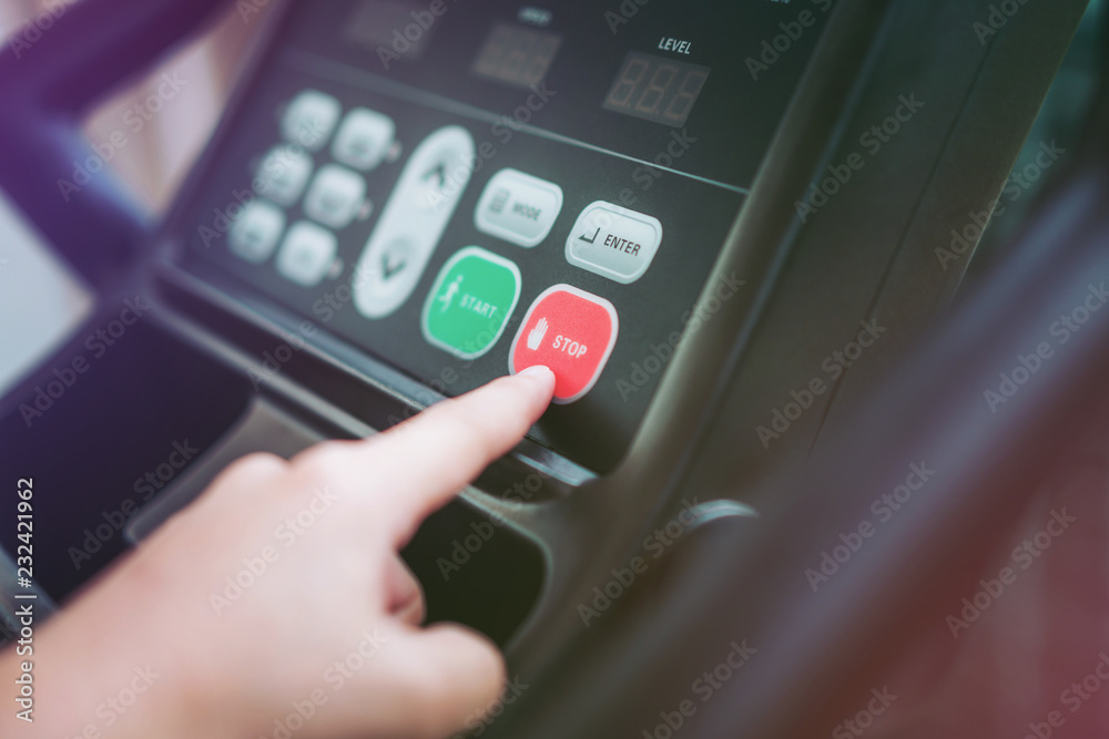 Give Up - Hand pressing stop button on treadmill control panel. Healthy lifestyle concept.