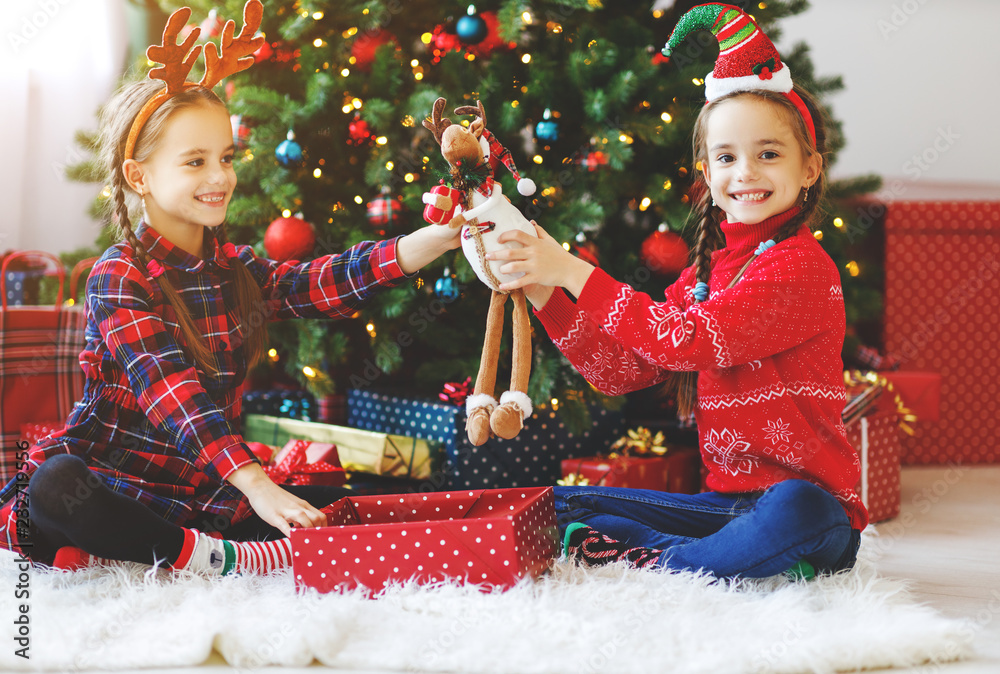 happy children girls with christmas gifts near tree in  morning