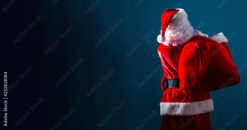 Santa holding a red sack on a dark blue background